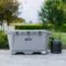Photo of The Wide Grizzly 450 Cold Plunge Tub - 1/4 Horsepower, in Gray. The cold plunge is sitting outdoors on a patio with the chiller attached. The lid is closed on the tub with the latches latched and there is a USA sticker on the bottom of the outside of the tub.